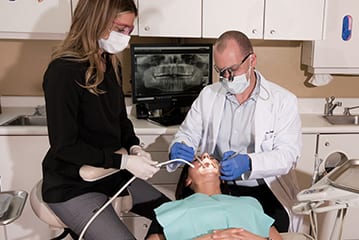 dental-assistant-helping-dentist-dr-ian-lowell-aspen-co-with-teeth-cleaning-of-dental-patient